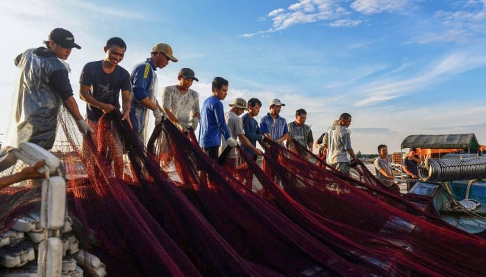 Ngư dân địa phương tại cảng cá Hòn Sơn với thuyền gỗ truyền thống lúc hoàng hôn