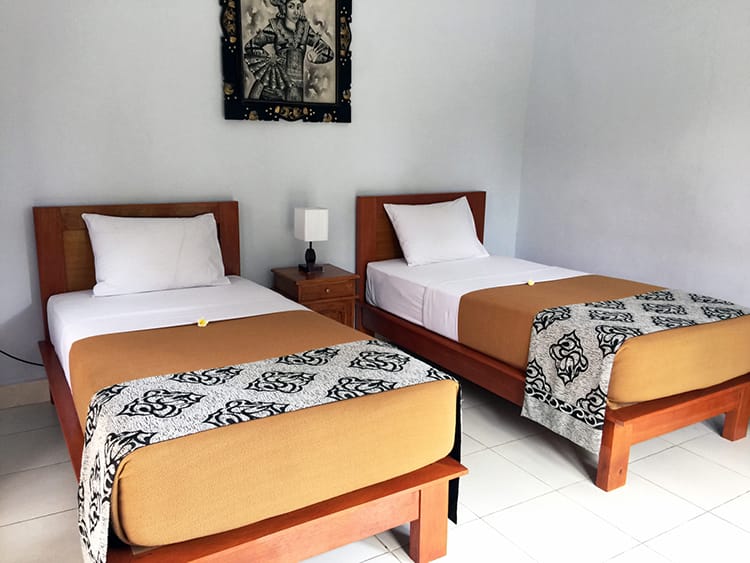 Hai chiếc giường đơn được bố trí gọn gàng trong một căn phòng tại homestay ở Bali, Indonesia