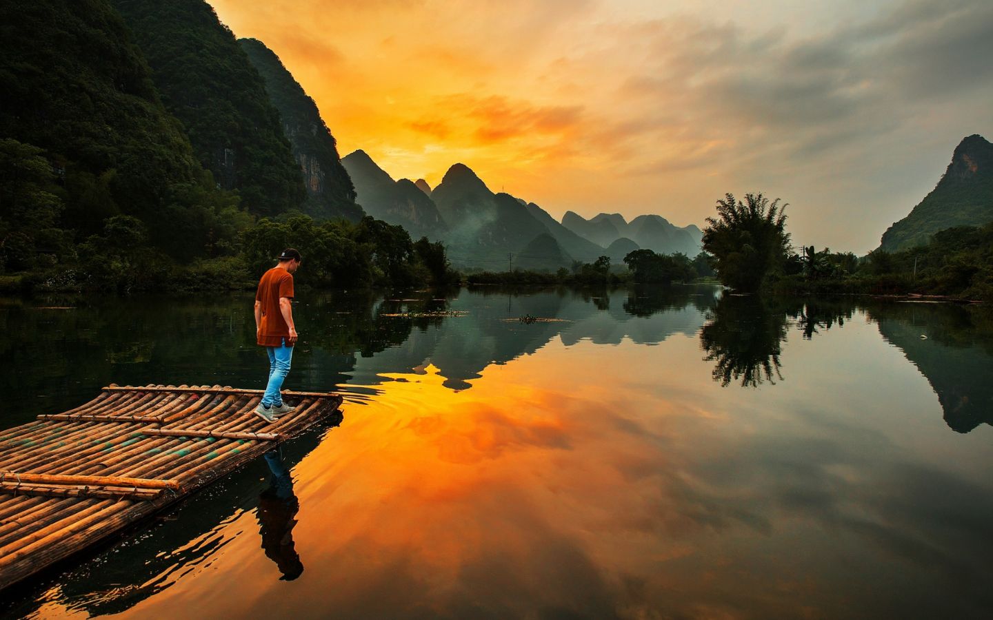 Người đứng trên bến gỗ ngắm hồ lúc hoàng hôn
