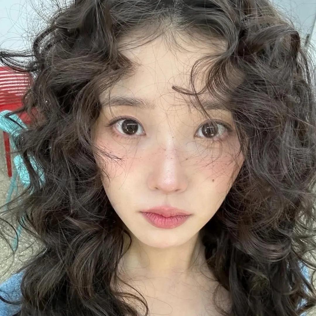 IU được trang điểm trẻ trung với má hồng và tàn nhang