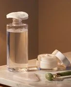 Chai nước tẩy trang micellar water và bông tẩy trang trên bàn trang điểm