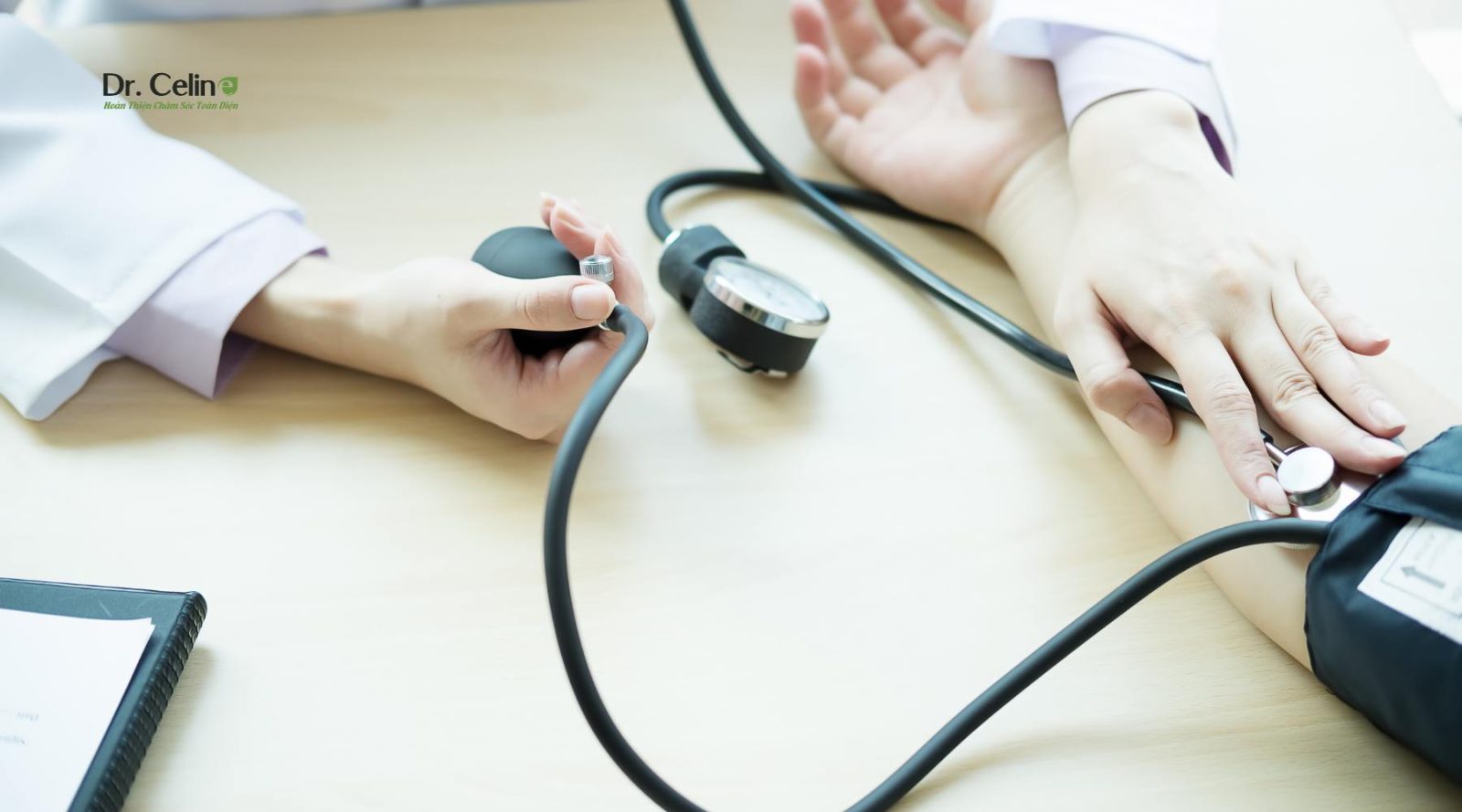 Bác sĩ đo huyết áp kiểm tra sức khỏe định kỳ cho người bệnh