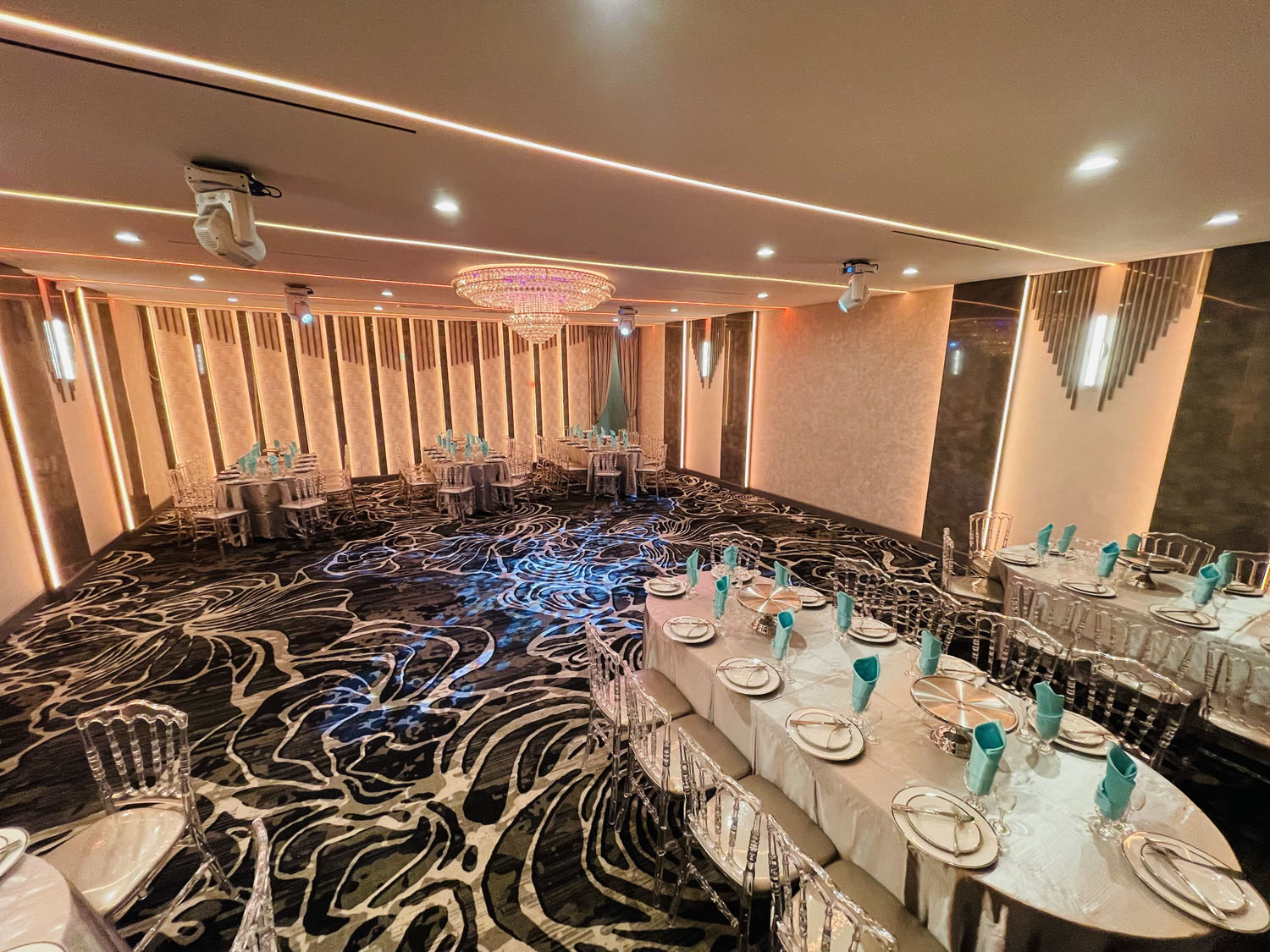 Ảnh sân tiệc được trang trí hoa tươi trắng vàng, bàn ghế sang trọng, đèn chùm, vải lụa