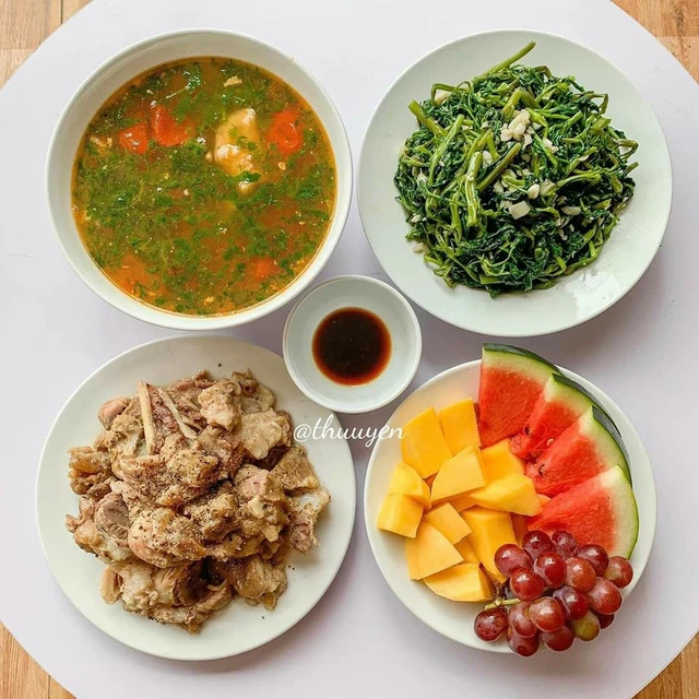 Mâm cơm nhà với đậu phụ, rau và canh bình dân, đủ chất