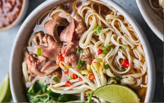 Tô phở bò hoàn chỉnh với thịt, bánh phở và rau thơm
