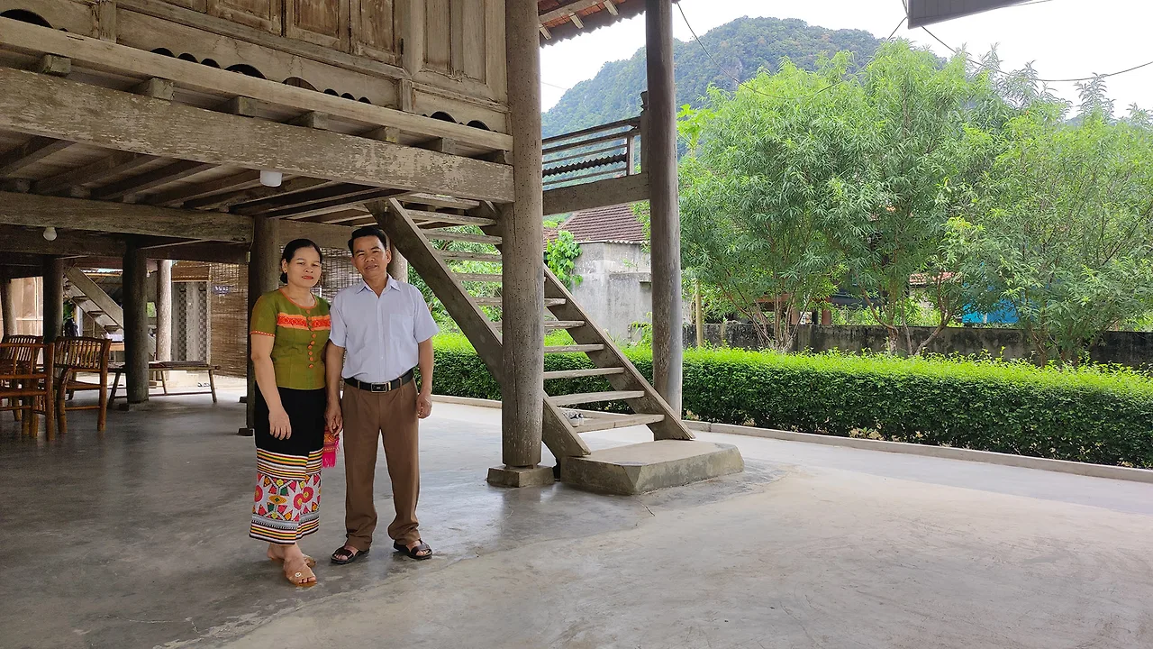 Hai vợ chồng người Thái bên khung cửa sổ nhà sàn truyền thống