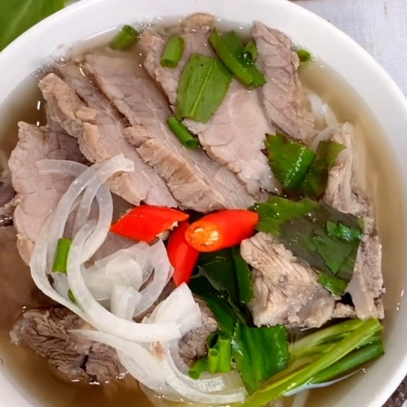 Tô phở bò thành phẩm nóng hổi, nước trong và thịt chín tới