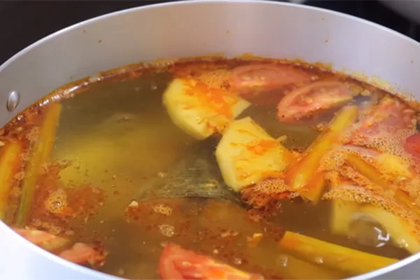 Nấu nước dùng bún cá ngừ với cà chua và thơm tạo màu sắc hấp dẫn