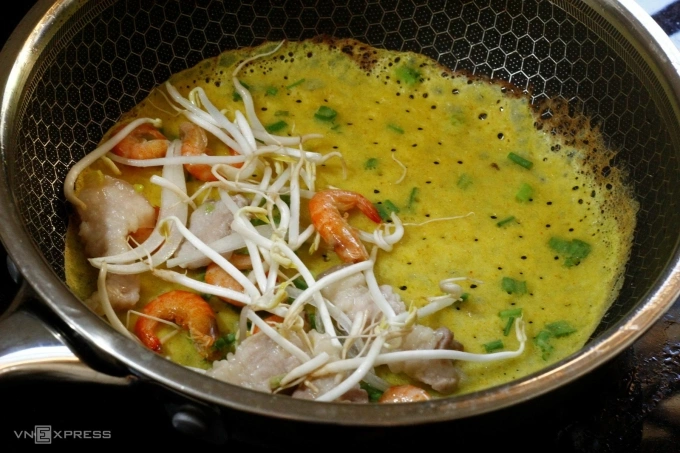 Đổ bột bánh xèo lên chảo nóng