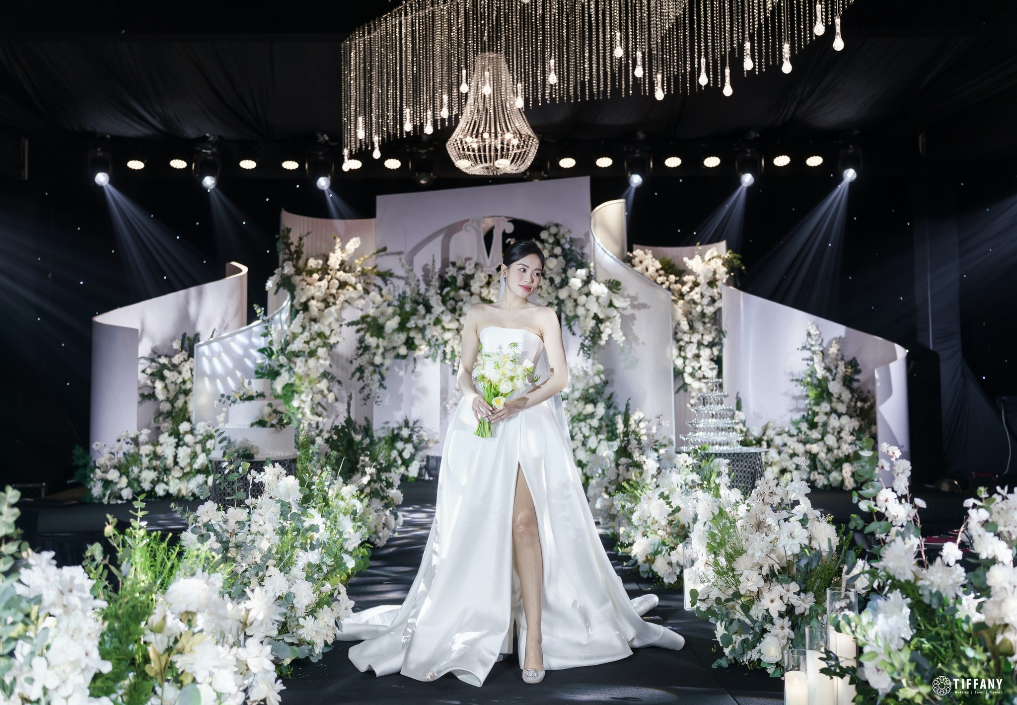 Không gian tiệc cưới được trang trí với hoa tươi và ánh sáng nâng cao