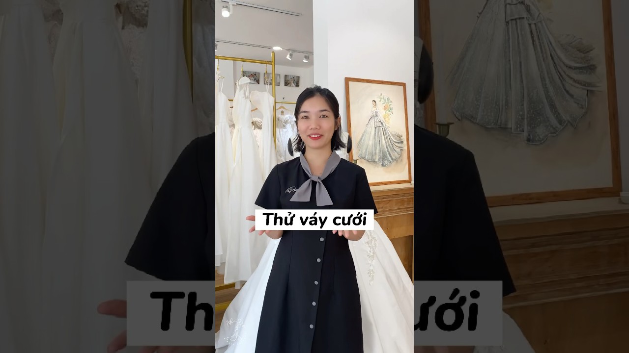 Hình ảnh cô dâu thử váy cưới với sự trợ giúp của chuyên viên
