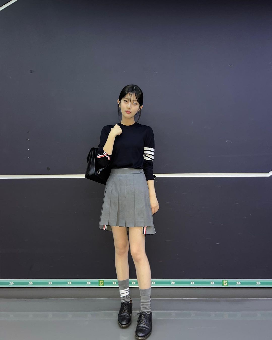 Outfit áo thun dài tay và chân váy xếp ly