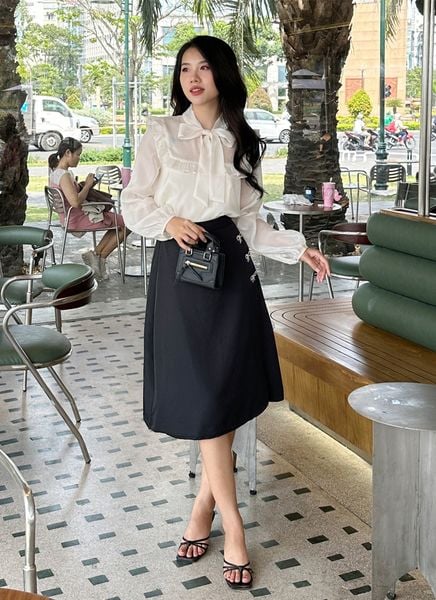 Phối áo blouse thắt nơ cùng chân váy xòe tạo nên diện mạo thanh lịch