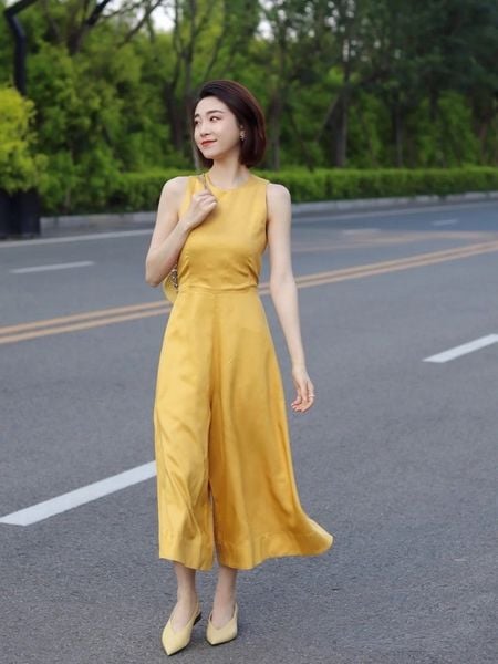Người phụ nữ mặc jumpsuit sát nách màu vàng