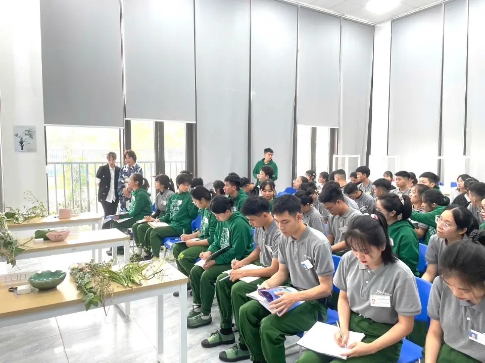 Người học đang căn chỉnh góc cắm hoa trên kenzan dưới sự hướng dẫn của nghệ nhân