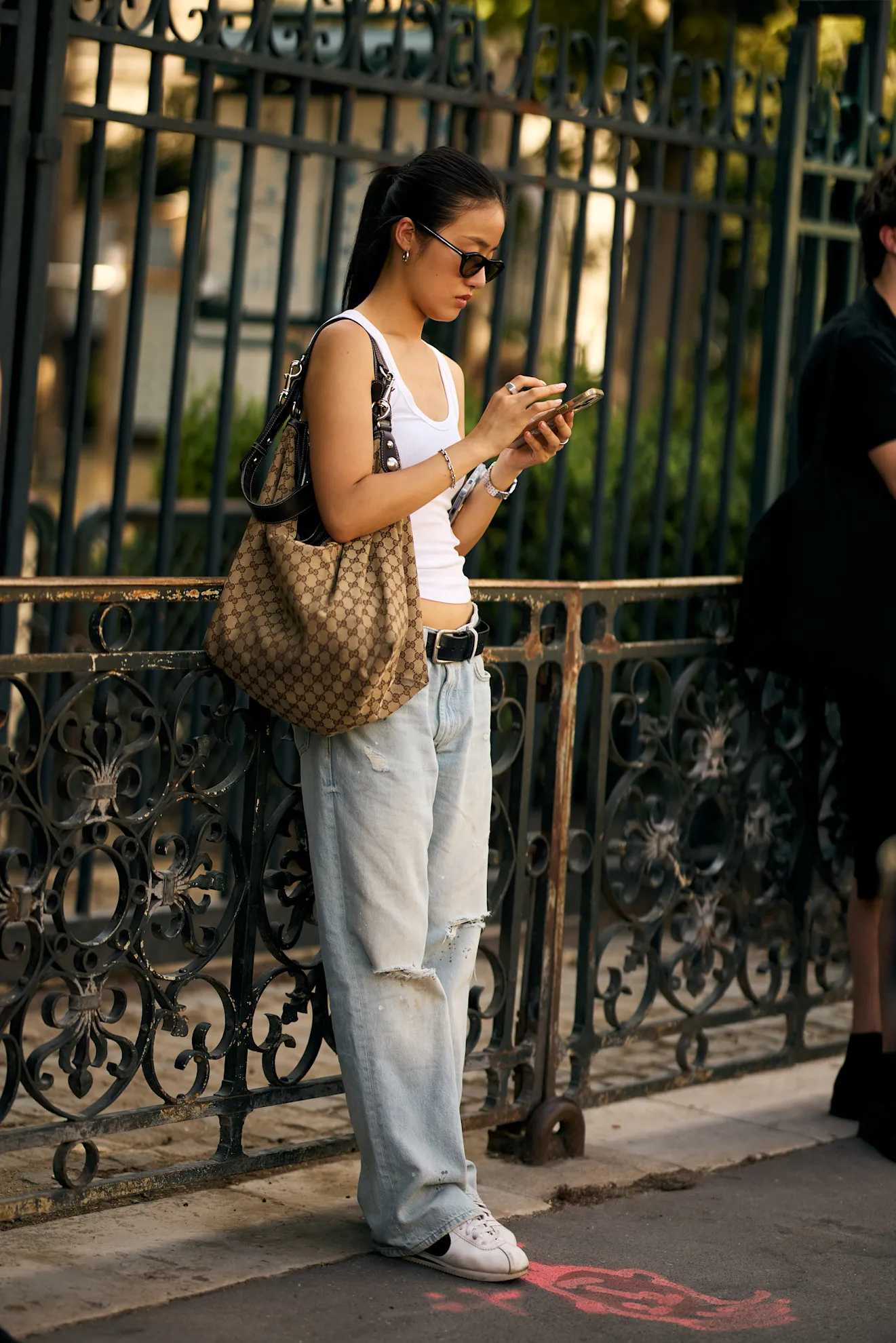Street style Paris với jeans crossover và sneakers
