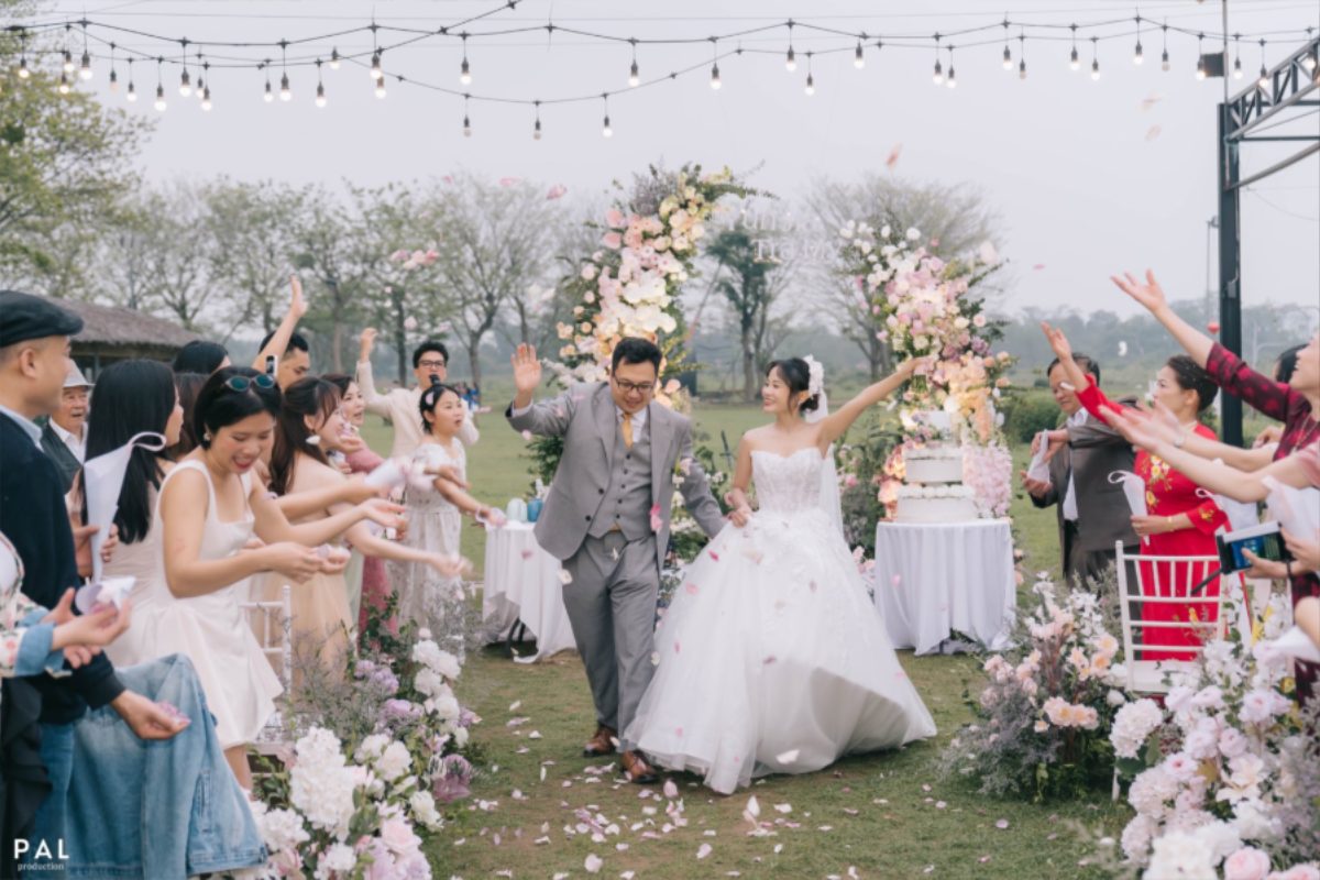 Tiệc cưới ngoài trời tại Nắng Sông Hồng với lối đi hoa tươi trắng tinh tế.