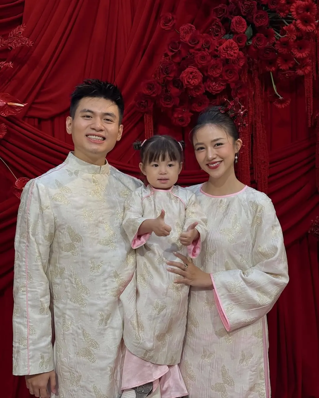 Gia đình cùng diện áo dài gấm màu be phối hồng làm tăng vẻ thanh tao, nền nã giữa không gian Tết