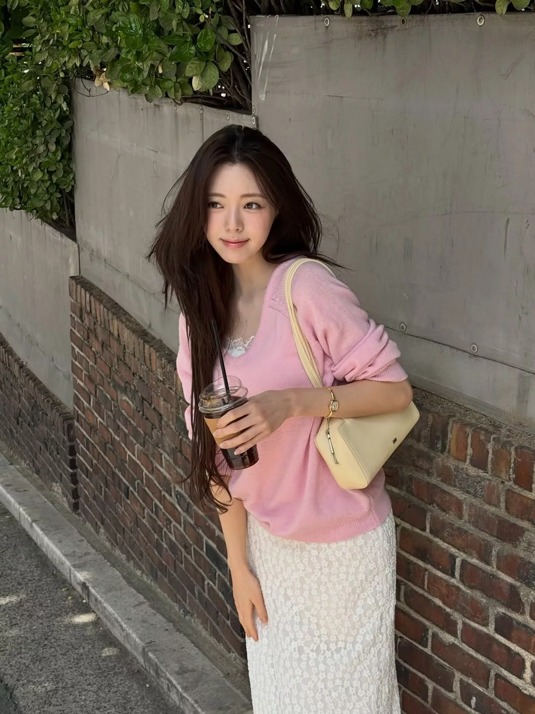 Áo dệt kim mỏng tông hồng pastel với chi tiết cổ chữ V hạ sâu mang đến cho Yuna một diện mạo dịu mát và ngọt ngào dưới nắng Hè.