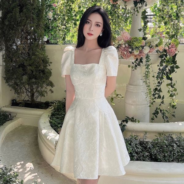Đầm gấm hoa tay phồng cổ vuông đính nơ ngực