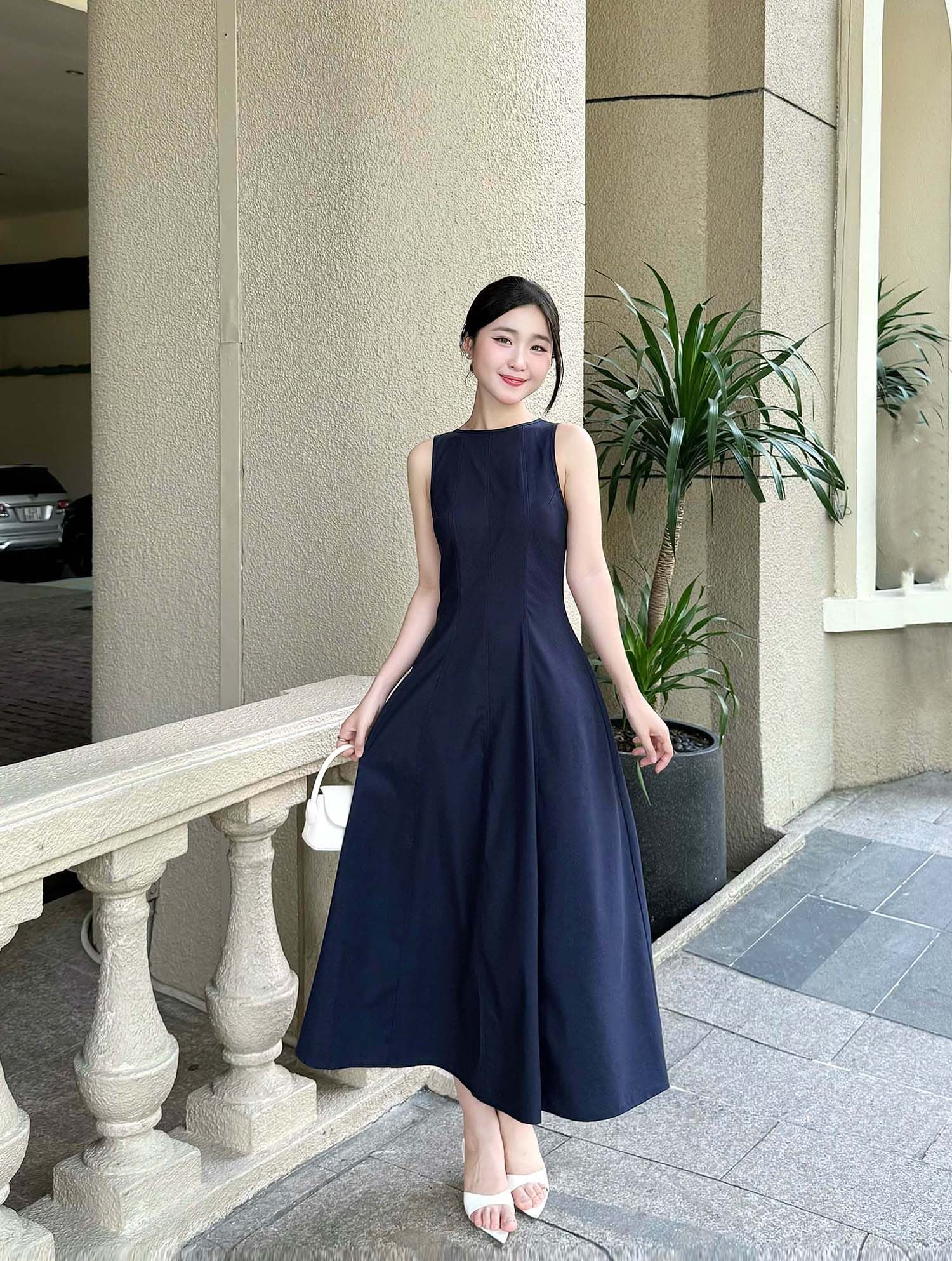 Mẫu đầm midi sát nách màu xanh dương tạo nên vẻ ngoài thanh lịch khi phối lớp