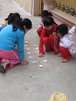 Bàn cờ ô ăn quan rải sỏi thực tế giúp trẻ hình dung vị trí quân cờ