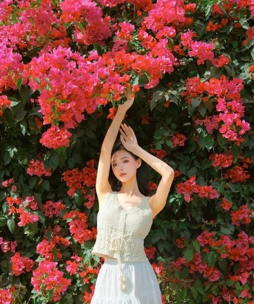 Dáng tạo chạm tay vào hoa giấy