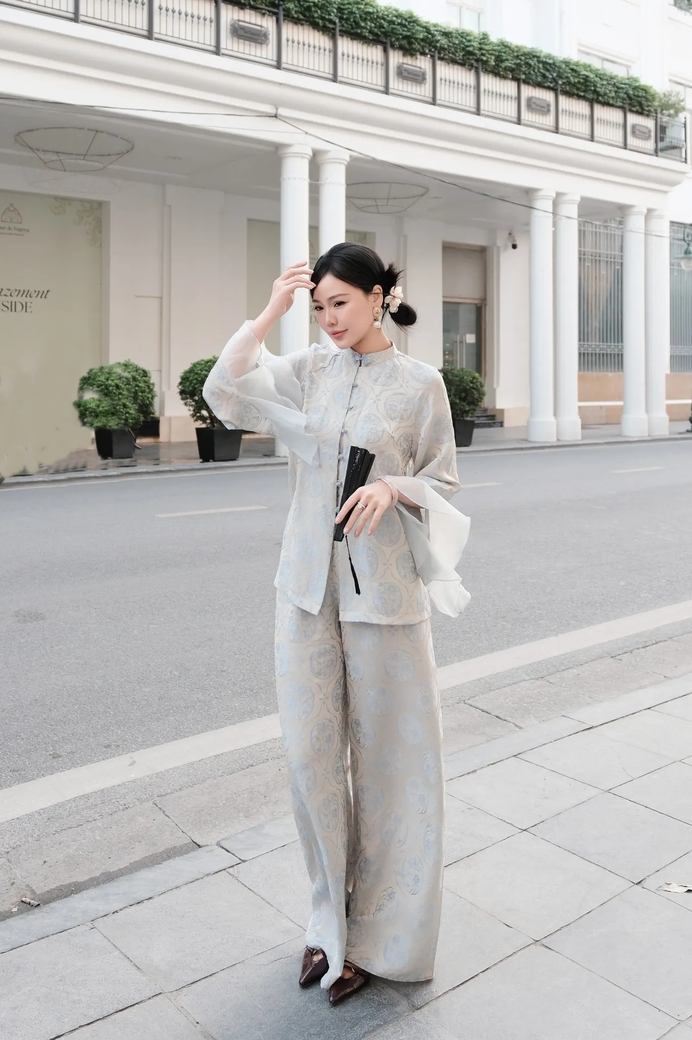 Bản phối áo bà ba tay loe cùng quạt mây tre đan tinh xảo làm bật lên nét giao thoa hoàn hảo giữa truyền thống và hơi thở đương đại.