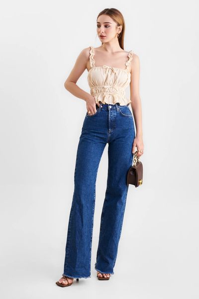 Áo linen hai dây bèo nhún tạo điểm nhấn mềm mại cho phần vai và ngực