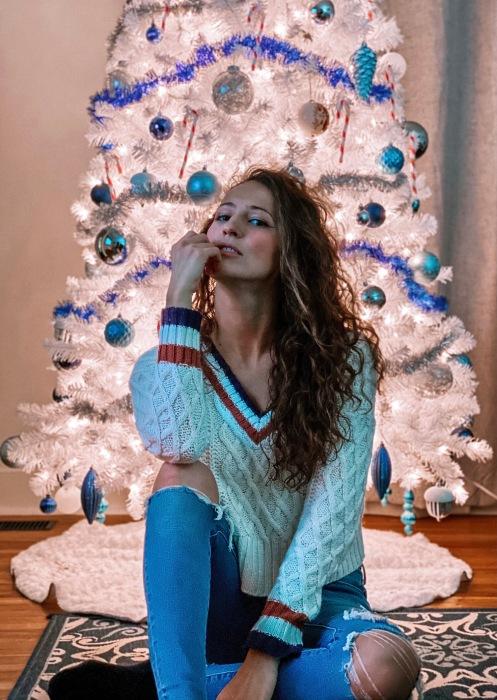 Dáng ngồi phía trước cây thông Noel