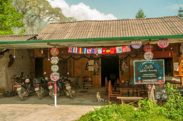 Gia đình Hmong chào đón du khách tại cửa nhà gỗ truyền thống