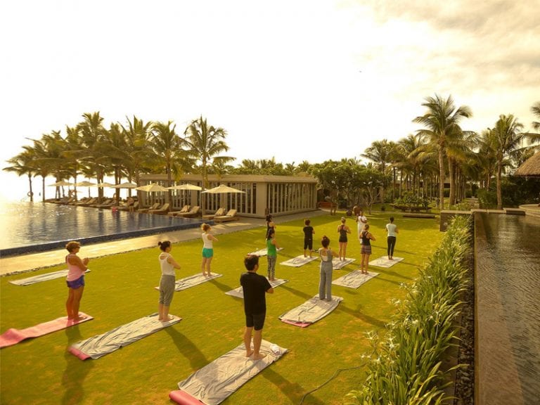 Khách nghỉ dưỡng thực hành yoga bên bờ biển tại resort cao cấp Việt Nam