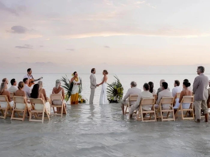 Cặp đôi tổ chức đám cưới trên bãi cát lộ thiên giữa biển lúc bình minh tại Kaneohe Bay Hawaii