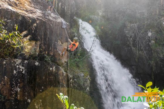 Những người tham gia canyoning trượt xuống dây từ một vách đá trên thác nước ở Đà Lạt