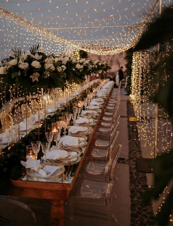 Romantic wedding venue decorated with fairy lights and floral arch