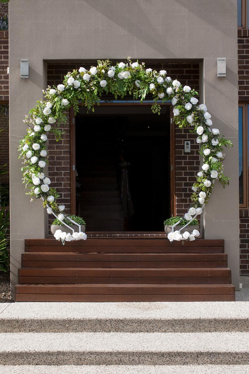 Wedding florist constructing 3D floral arch frame with metal structure