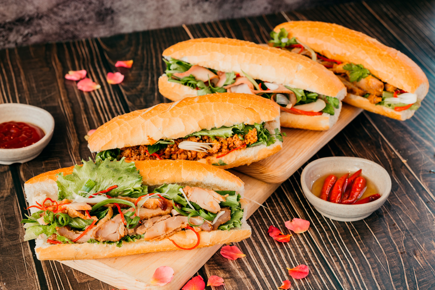 Vietnamese banh mi sandwich with pate, pickled vegetables and fresh herbs being prepared