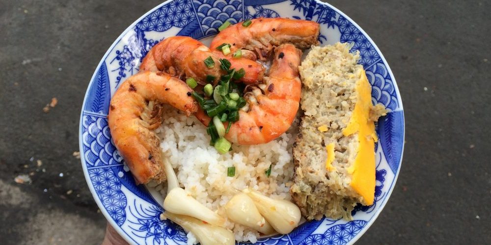 Broken rice com tam Saigon with grilled pork and fried egg on a plate