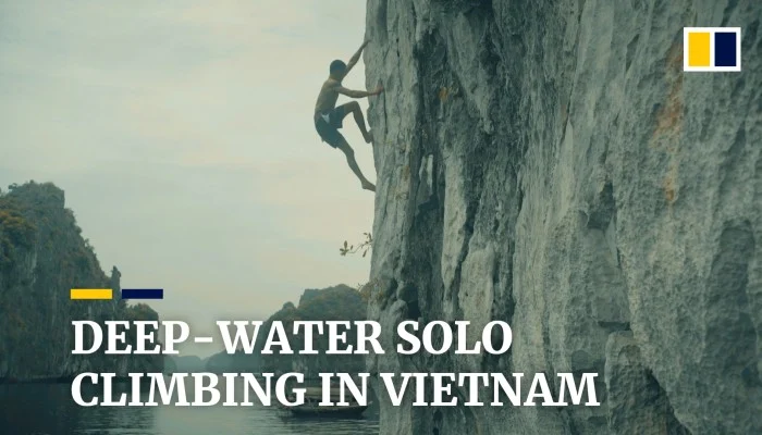 Deep water soloing jump from cliff into Ha Long Bay emerald water