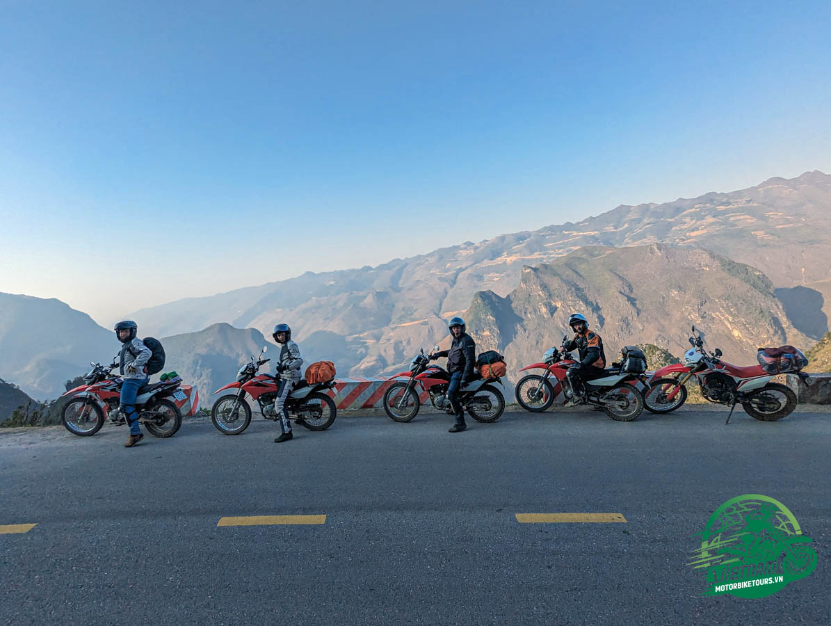 Motorbike rider on winding mountain road in Ha Giang with limestone karst landscape in background