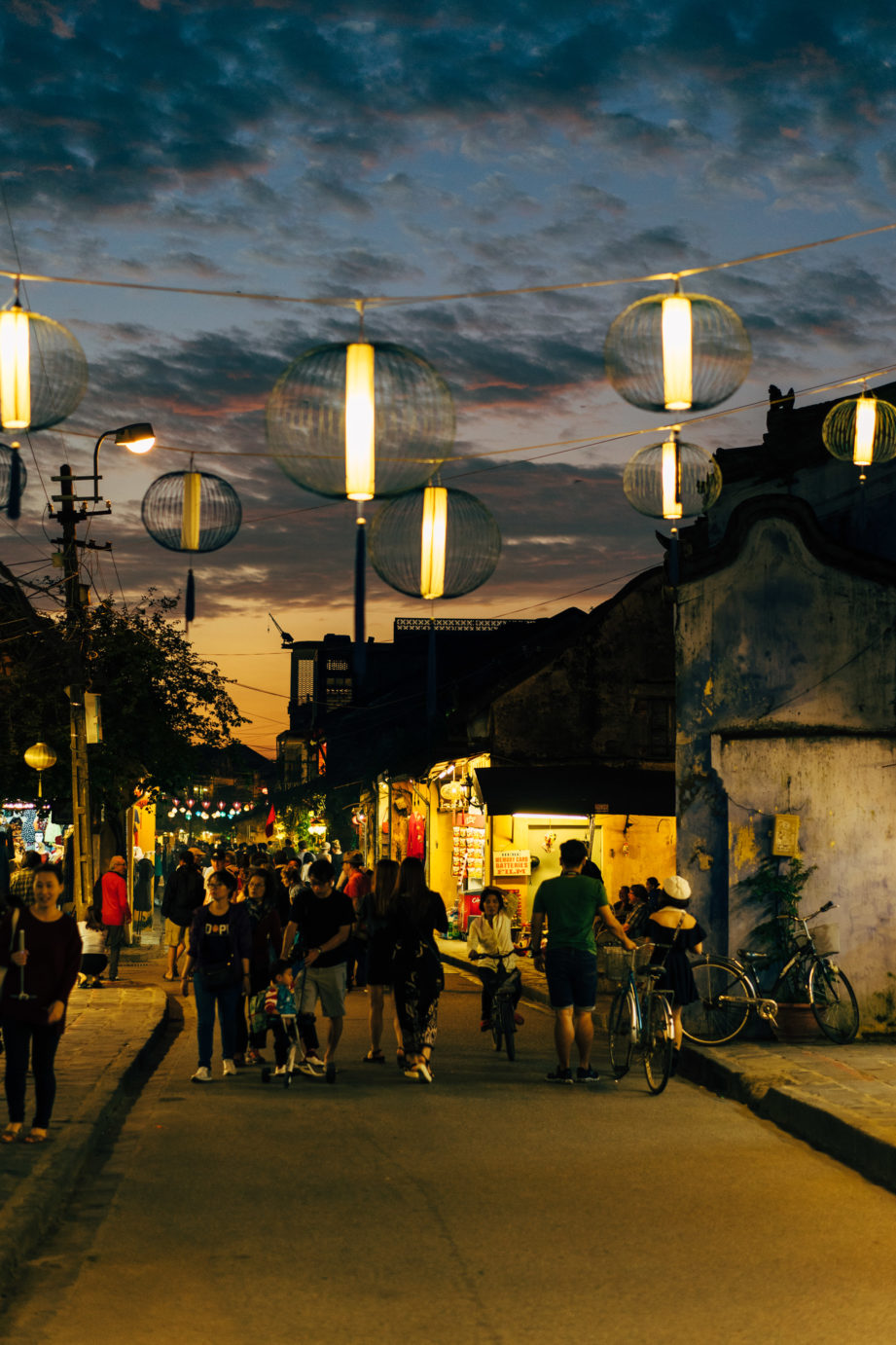 Solo traveler walking through Hoi An ancient town lantern streets at night